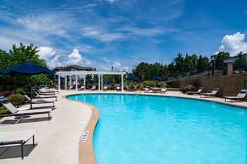 a large swimming pool with chairs and umbrellas at a resort at Century New Holland, Gainesville, GA